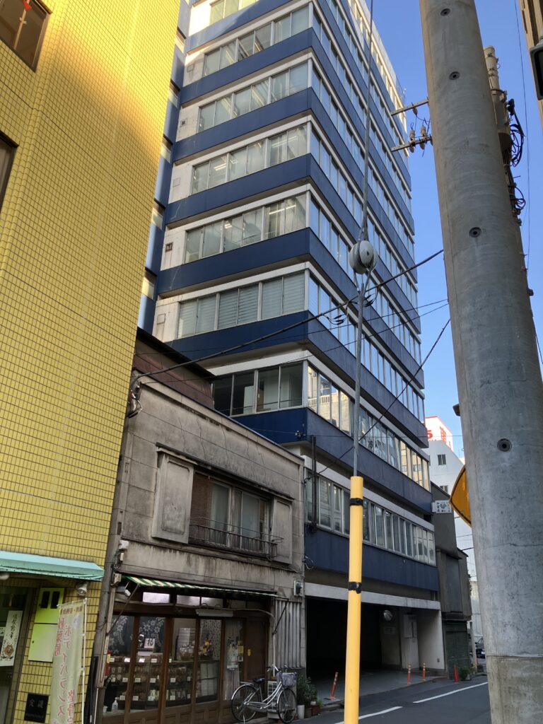 黄色いビルと青いビルの間にある建物